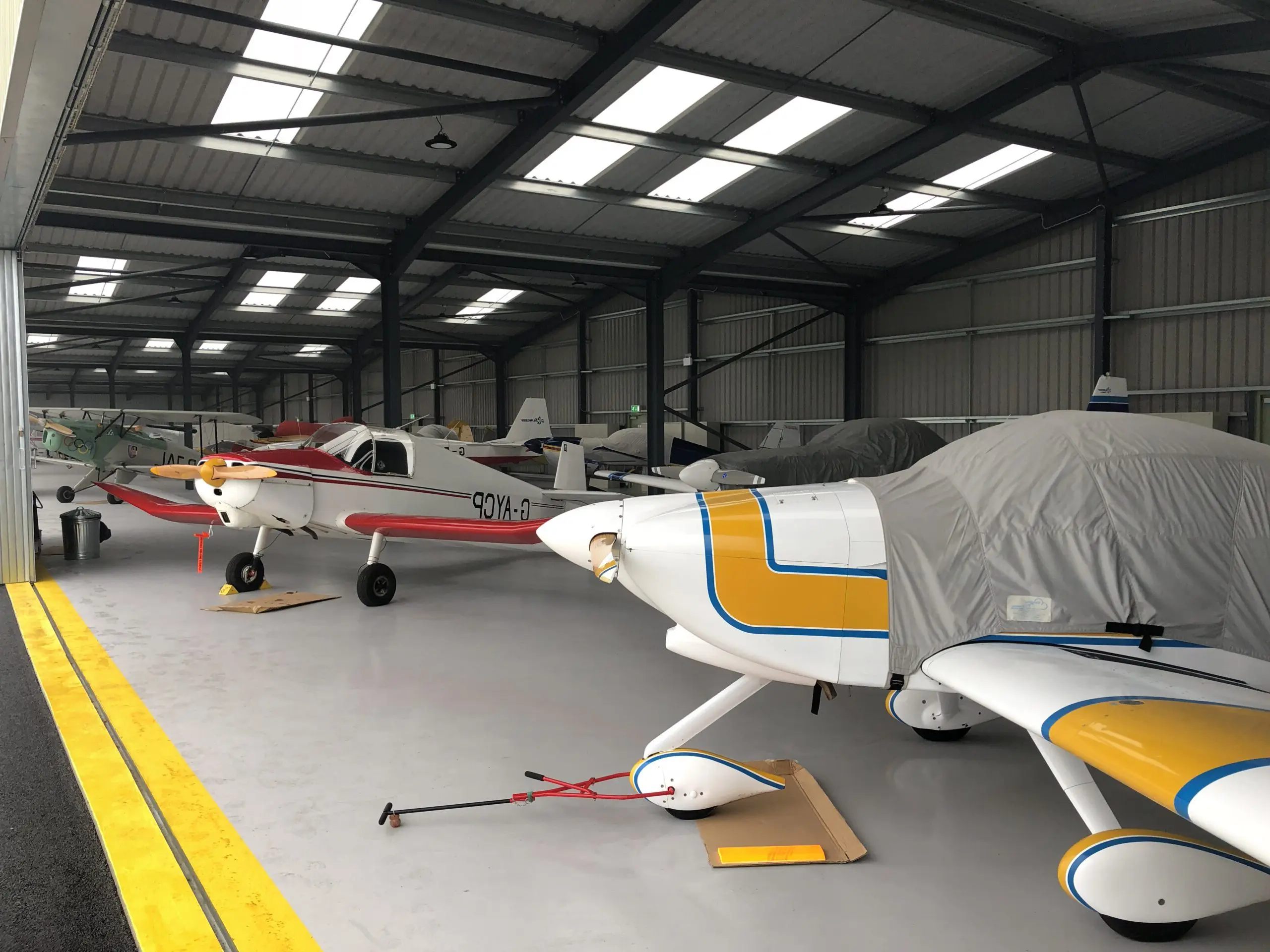 Large aeroplane hanger with many private aircraft at Breighton Aerodrome