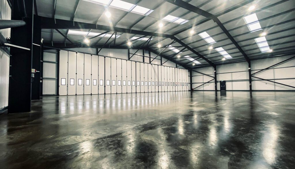 Bespoke steel framed building at Elstree Aerodrome in Hertfordshire with groundworks and full construction works and insulated Aircraft Jewers Doors by Springfield Steel Buildings. The building will store aircraft, aeroplanes and helicopters
