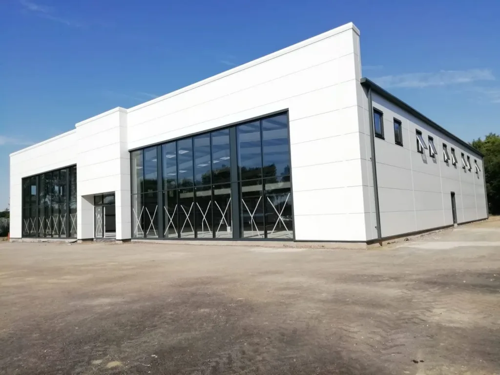 Large Car Showroom with parapet roof and Large glazing, clad in white Kingspan Micro-rib